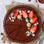 Vegane Valentinstags-Tart mit cremiger Himbeer- und Schokoladenschicht auf knusprigem Nussboden